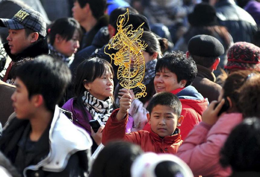 A young boy holds a dragon-shaped sugar painting at a temple fair held during the Spring Festival holiday in Tianjin, north China, Jan. 25, 2012. The Spring Festival, or the Chinese Lunar New Year, which fell on Jan. 23 this year, marked the start of the Year of Dragon, according to the Chinese zodiac. [Xinhua photo]