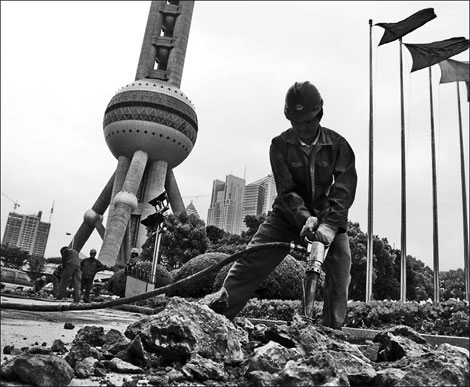 A construction site near the Oriental Pearl TV Tower in Shanghai. Revenues from land sales in Shanghai and Beijing are expected to decline this year, since there is no sign that curbs on the property market will ease.
