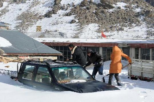 Local residents clear away snow in Nyalam County, southwest China's Tibet Autonomous Region, Feb. 12, 2012. Nyalam County was hit by a heavy snowfall on Feb. 7-9. [Xinhua] 