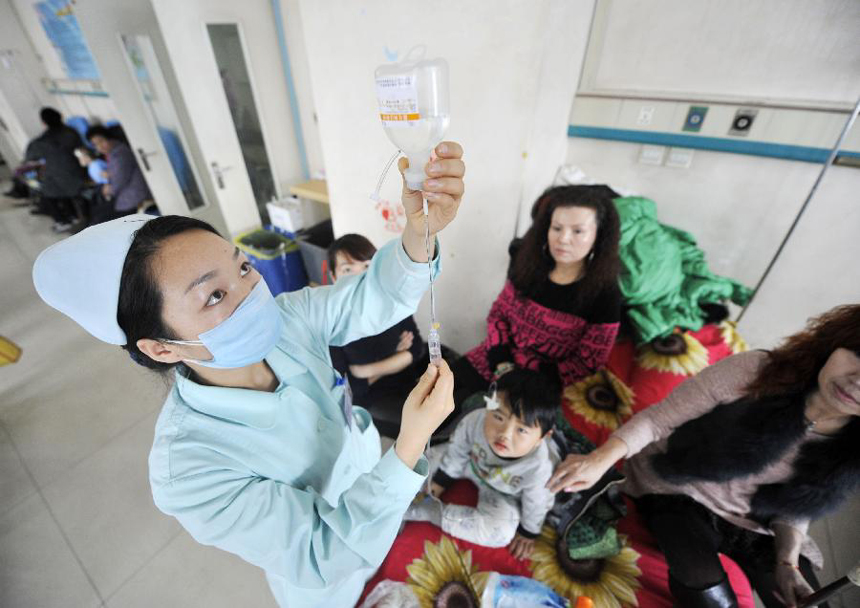 A nurse takes care of a child at Yinchuan Maternal and Children Health Hospital in Yinchuan, captial of northwest China's Ningxia Hui Autonomous Region, Feb. 12, 2012. Many children caught cold due to sharp temperture decline, rendering the number of children getting infusion to almost 300 people per day in the hospital. [Xinhua photo]