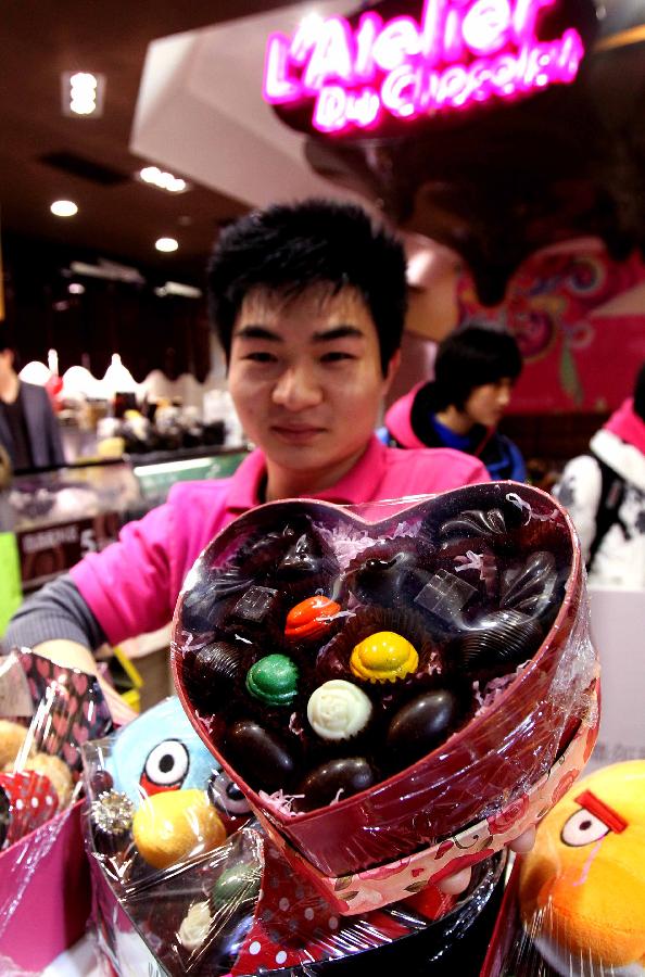 A staff of a chocolate shop displays a special box of chocolate for the Valentine's Day in Shanghai, east China, Feb. 13, 2012. For the approaching Valentine's Day, many shops made special festival presents for lovers. 