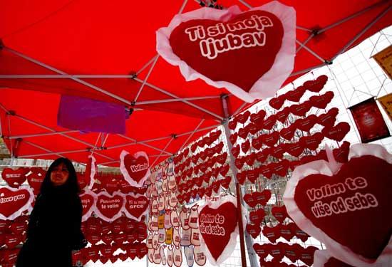 A woman looks at heart-shaped cushions with proclamations of love that are selling for 1 euro ($1.30) each ahead of Valentine's Day in the central Bosnian town of Zenica February 13, 2012.