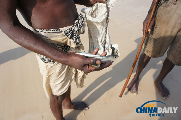 A stilt fisherman holds his catch in Weligama, a town on the southern coast of Sri Lanka. Photo taken on February 1, 2012. [Photo/chinadaily.com.cn] 