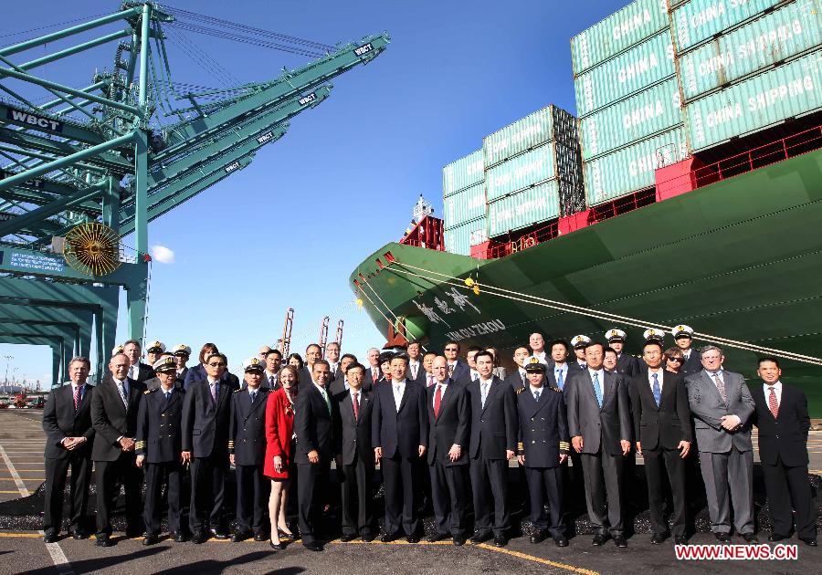 Chinese Vice President Xi Jinping (C, front) poses for photos with employees of China Shipping as he tours the company at the Port of Los Angeles in Los Angeles, California, the United States, on Feb. 16, 2012. [Lan Hongguang/Xinhua]