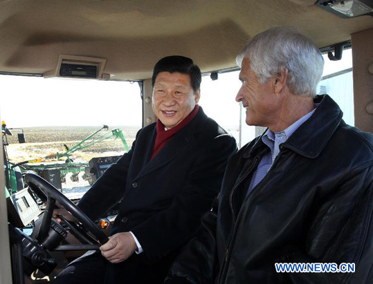 Chinese Vice President Xi Jinping (L) talks with farmer Rick Kimberley as they sit in the cab of a tractor in Des Moines, Iowa, the United States, Feb. 16, 2012. Xi visited Kimberley's farm Thursday. [Xinhua]