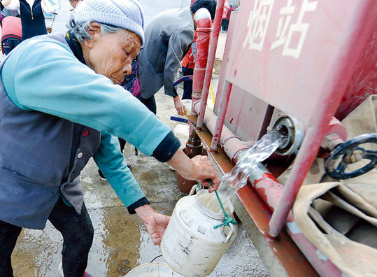 An elderly resident gets water recently at a water supply station in Weize village, Qujing, in Southwest China's Yunnan province. Severe drought has caused a drinking water shortage that affects more than 430,000 people in Qujing. [Xinhua] 