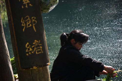 A woman washes clothes next to the river running through Heshun ancient town. In the winter season, when there are fewer tourists, local life returns to its quiet rituals. [Photo:CRIENGLISH.com] 