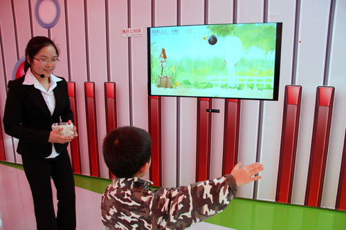 A child plays a video game in one of the exhibition rooms at the Strawberry Expo Garden in Changping district, Beijing. [Photo: CRIENGLISH.com]