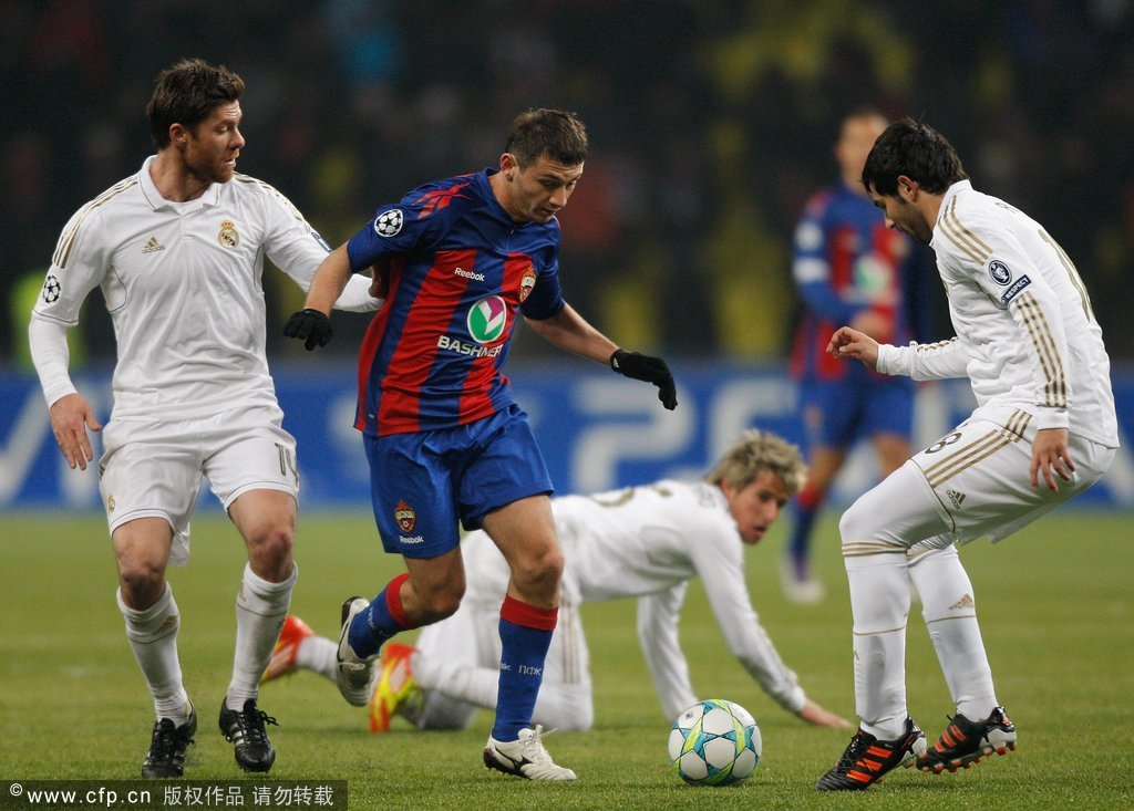  Alan Dzagoev (C) of CSKA Moscow battles for the ball with Xabi Alonso (L) and Raul Albiol of Real Madrid during the UEFA Champions League round of 16, first leg match between CSKA Moscow and Real Madrid at the Luzhniki Stadium on February 21, 2012 in Moscow, Russia. 