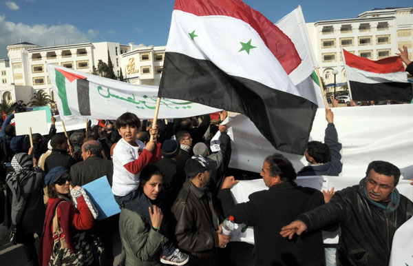 Tunisian and Syrian's Bashar al Assad Supporters shout slogans during a demostration in front of the conference hotel during the first 'Friends of Syria' conference in Tunis on February 24, 2012. [AFP/Xinhua]