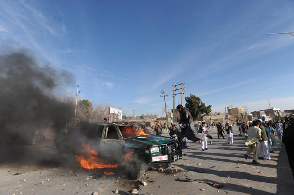A police car is seen on fire as people protest against the alleged Quran burning by U.S. troops in Herat, west Afghanistan, on Feb. 24, 2012. [Xinhua/Sardar] 