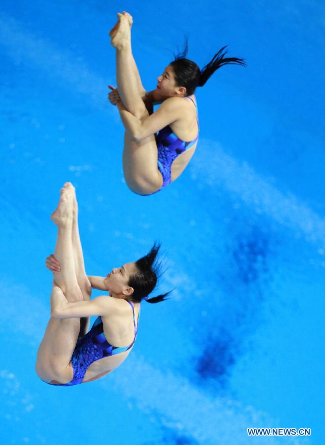 He Zi (Top) and Wu Minxia of China compete during the Women's Synchronized 3m Springboard Final at the FINA Diving World Cup at the Olympic Aquatics Centre in London, Britain, Feb. 25, 2012. He and Wu won the gold medal with 345.30 points. [Xinhua]