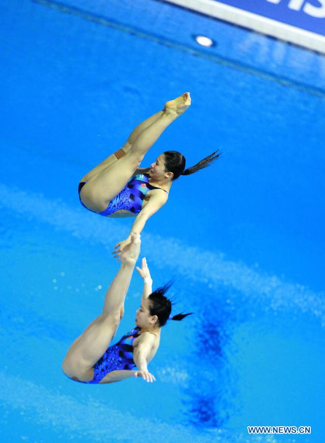 He Zi (Top) and Wu Minxia of China compete during the Women's Synchronized 3m Springboard Final at the FINA Diving World Cup at the Olympic Aquatics Centre in London, Britain, Feb. 25, 2012. He and Wu won the gold medal with 345.30 points. [Xinhua]