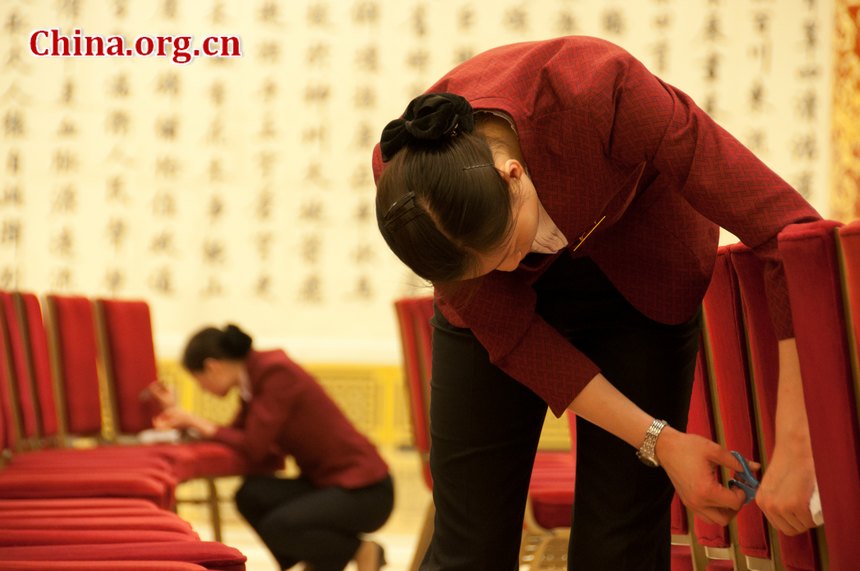 Staff members of the Great Hall of the People tidy the chairs at the Golden Hall, the venue for important press conference during China&apos;s National People&apos;s Congress (NPC) and CPPCC sessions on the afternoon of Thursday, March 1, 2012 [China.org.cn]