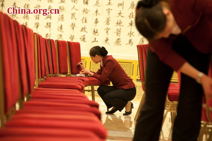 Staff members of the Great Hall of the People tidy the chairs at the Golden Hall, the venue for important press conference during China's National People's Congress (NPC) and CPPCC sessions on the afternoon of Thursday, March 1, 2012 [China.org.cn]