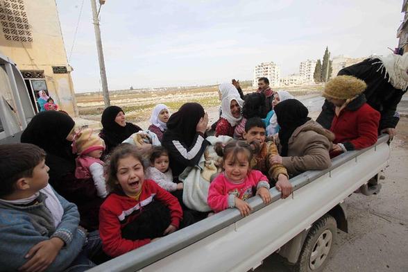 Syrian women and children escape from their homes after Syrian Army tanks attacked Syrian city of Idlib, Feb. 14, 2012. [Xinhua] 