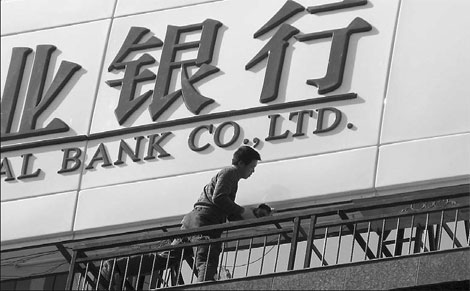 A worker installing billboards at a bank in Shiyan, Hubei province. Industry analysts said the ratio of non-performing loans at Chinese lenders may continue to rise this year. [China Daily]