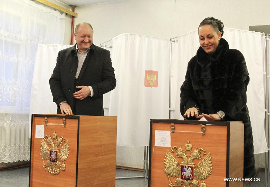 Kamchatska governor Vladimir Iliukhin and his wife cast their ballots in the presidential election at NO.177 polling station in the Yelizovo, Kamchatska, Russia, March 4, 2012. Voting began on Sunday in Russia's Far East in the presidential election. (Xinhua) 