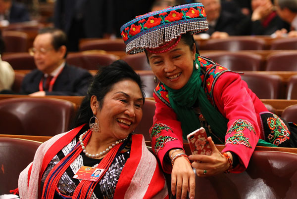 Two members of the Chinese People's Political Consultative Conference National Committee capture the memeries with a mobile phone at the opening ceremony of this year's session in Beijing, March 3, 2012. [Photo by Zou Hong/China Daily] 