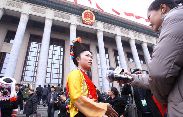 Liang Xiaodan, an ethnic group member of the Chinese People's Political Consultative Conference National Committee is interviewed prior to the opening ceremony of this year's session in Beijing, March 3, 2011. [Photo/Xinhua] 