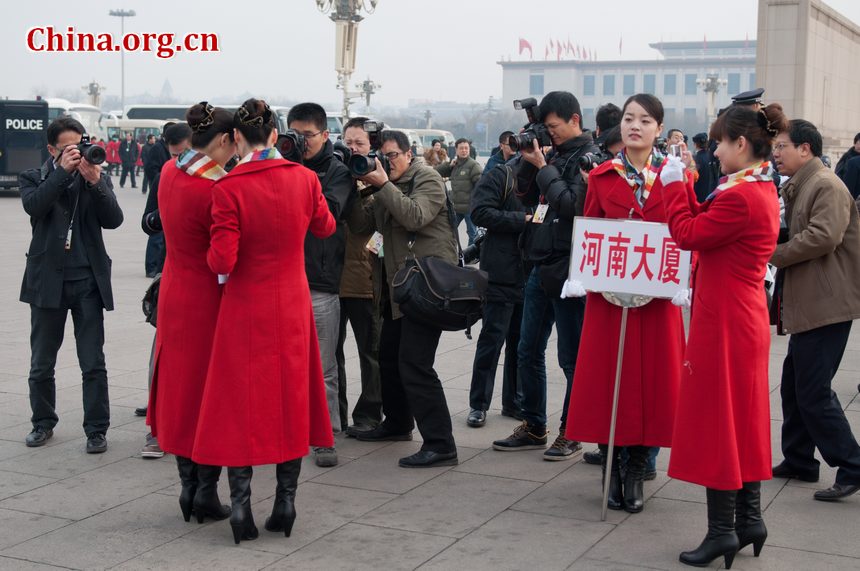 Hotel staff members serving the delegations to the National People's Congress (NPC) pose for self photos at the Tian'anmen Square on Sunday, March 4, 2012, in Beijing, China, one day prior to the NPC's opening ceremony on the morning of March 5 at the Great Hall of the People. Their poses attract photojournalists from both home and abroad. [China.org.cn]