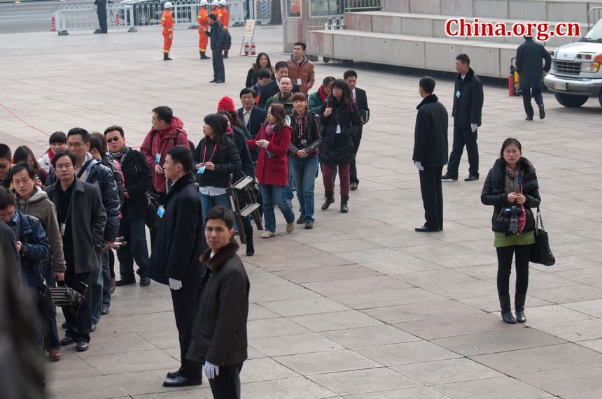 Journalists from both domestic and international press queue up for security check before entering the Great Hall of the People in Beijing, China, on Sunday morning, March 4, 2012, to report the press congress to be held by the NPC authorities. [China.org.cn]