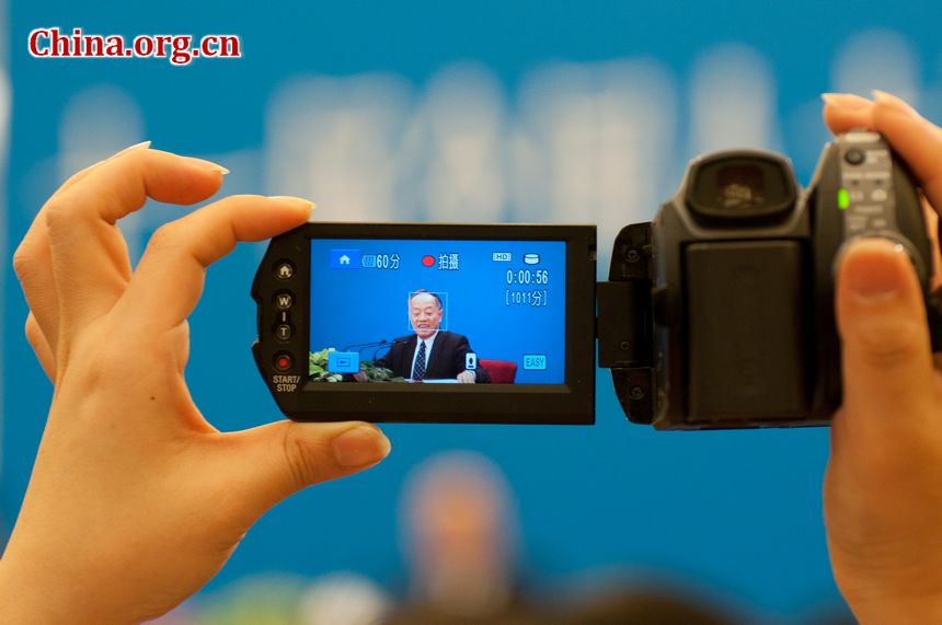A journalist shoots video footage of Li Zhaoxing, spokesperson for the Fifth Session of the 11th NPC, taking quetions from the press. [China.org.cn]