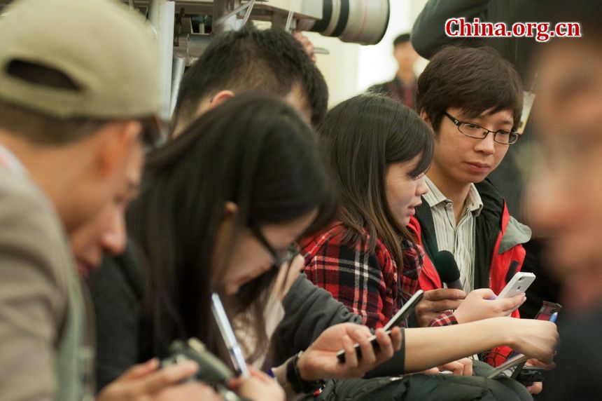 Reporters from both national and international press organization send real-time information via smartphones at the press conference of the Fifth Session of the 11th National People&apos;s Congress (NPC) held at the Golden Hall, the Great Hall of the People in Beijing, China on Sunday morning. [China.org.cn]