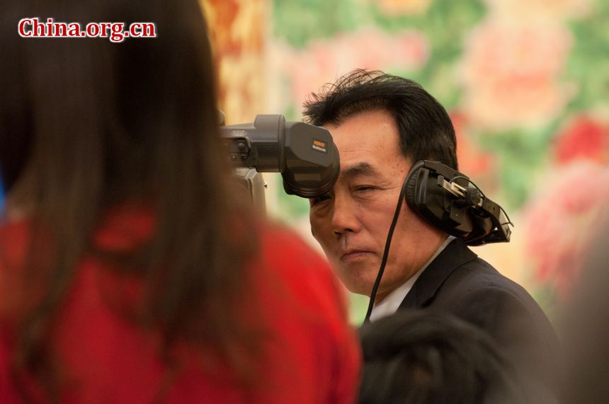 A TV crew man films a journalist while she stands up to pose questions to Li Zhaoxing, the spokesperson for the Fifth Session of the 11th National People&apos;s Congress (NPC). [China.org.cn]