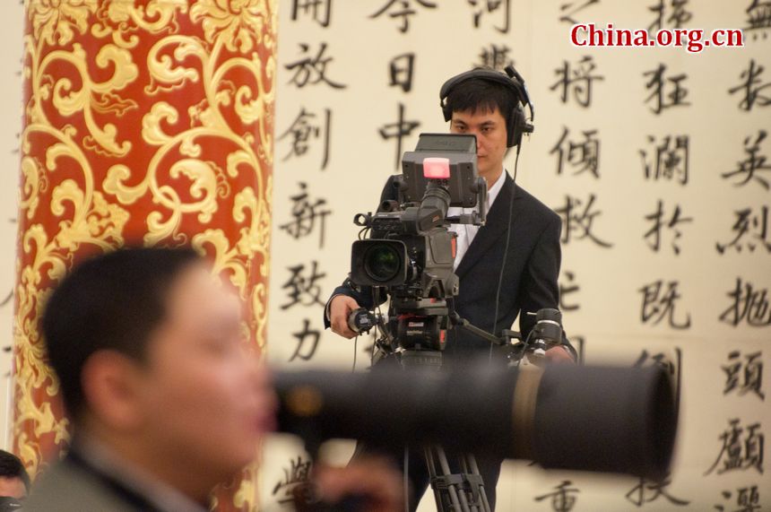 A TV crew man films other photojournalists during the press conference of the Fifth Session of the 11th National People&apos;s Congress (NPC). [China.org.cn]