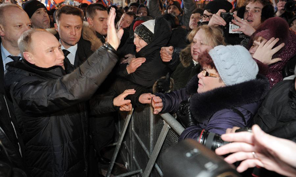 Russia's presidential candidate and incumbent Prime Minister Vladimir Putin (1st L) waves to his supporters during a gathering in Moscow, March 4, 2012. Putin attended the gathering with Russian President Dmitry Medvedev. [Xinhua/RIA Novosti]