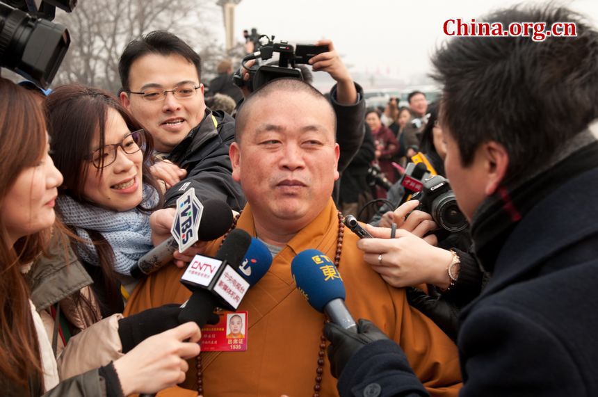 Shi Yongxin, the current abbot of the Shaolin Temple is surrounded by the press as he walks in to the Great Hall of the People to attend the annual National People&apos;s Congress (NPC) session on Monday, March 5, 2012 in Beijing, China. Shi Yongxin is the Chairman of the Henan Province Buddhists Association. Besides a delegate to the NPC, he is also one of the first Chinese monks ever to get a BA degree. [China.org.cn]