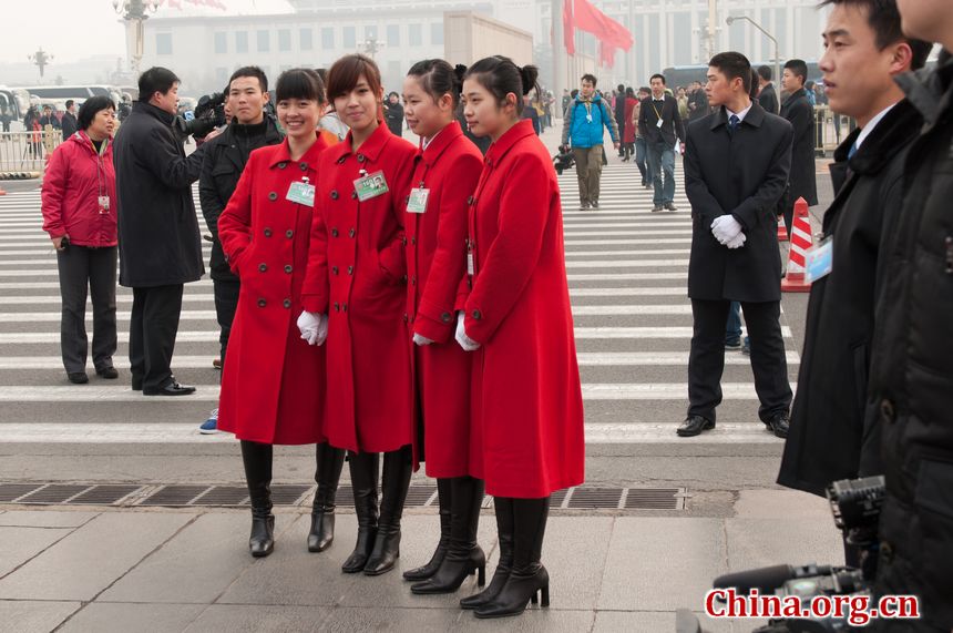 Staff workers from the hotels that host the delegates to the 11th National People&apos;s Congress (NPC) beam at the lens amid the opening ceremony of the the Congress&apos; fifth annual session. [China.org.cn]