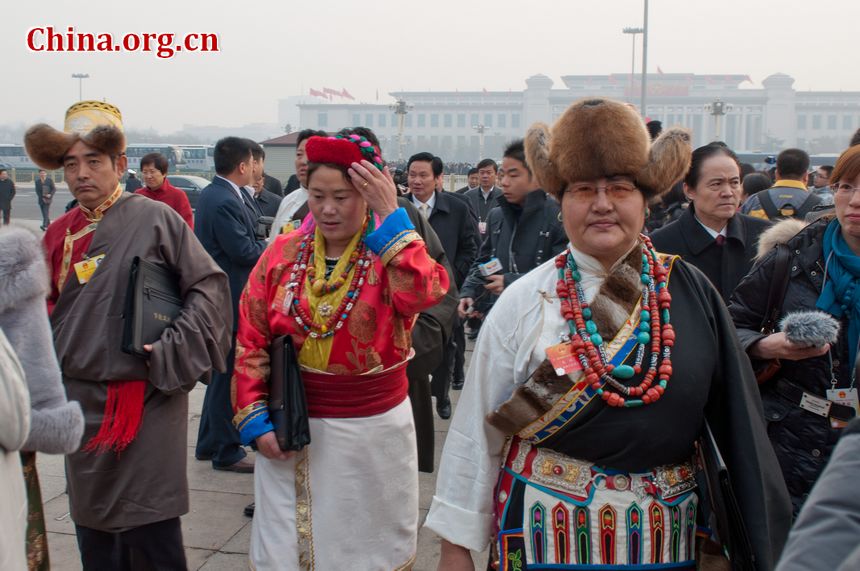 Delegates from China&apos;s ethnic groups beam beam at the lens and pose for photos as they walk into the Great Hall of the People to attend the opening ceremony of the Fifth Session of the 11th National People&apos;s Congress (NPC) on Monday, March 5, in Beijing, China. [China.org.cn]
