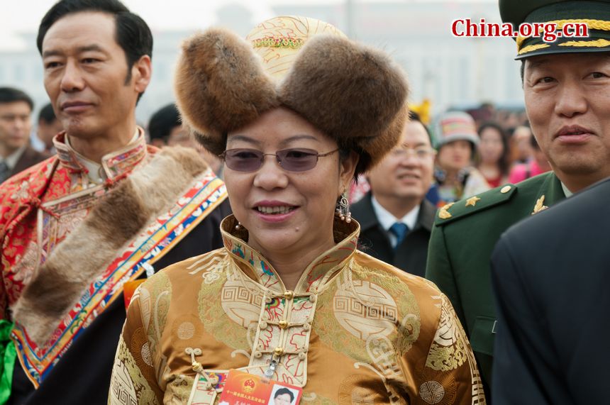 Delegates from China&apos;s ethnic groups beam beam at the lens and pose for photos as they walk into the Great Hall of the People to attend the opening ceremony of the Fifth Session of the 11th National People&apos;s Congress (NPC) on Monday, March 5, in Beijing, China. [China.org.cn]