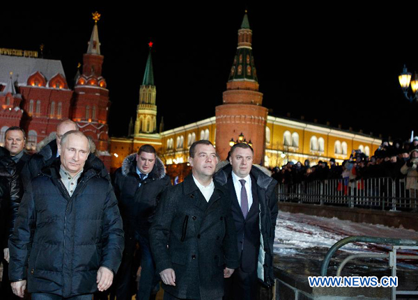 Russian President Dmitry Medvedev (2nd L) walks with Russia's presidential candidate and incumbent Prime Minister Vladimir Putin (1st L) as they attend a gathering in Moscow, March 4, 2012. [RIA Novosti/Xinhua]