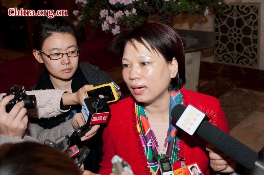 A delegte from Zhejiang Province delegation is surrounded by reporters as she takes a break outside the main conference hall on Monday morning, March 5, 2012. [China.org.cn]