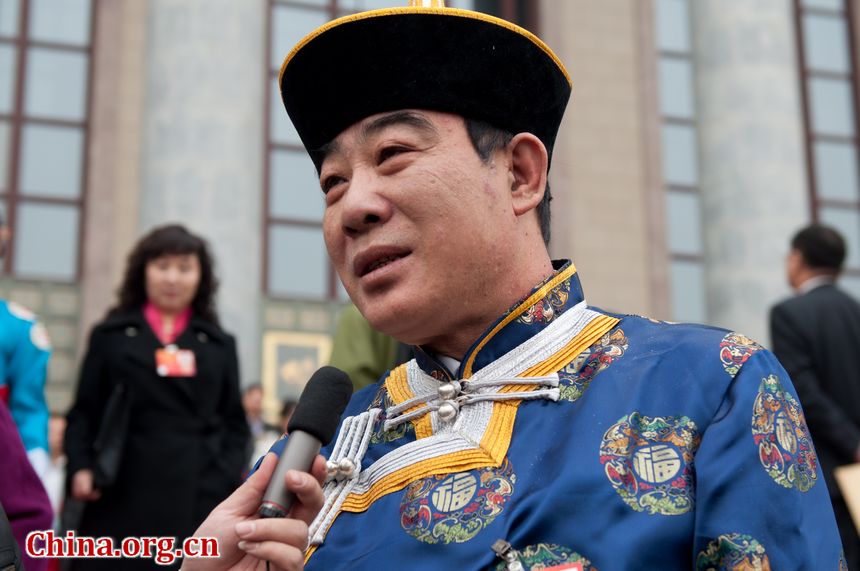 Guo Jian, Director of Hall of Agriculture and Animal Husbandry, Inner Mongolia, takes questions from Inner Mongolia Satelite TV as he walks out of the Great Hall of the People in Beijing, China on Monday, March 5. [China.org.cn]