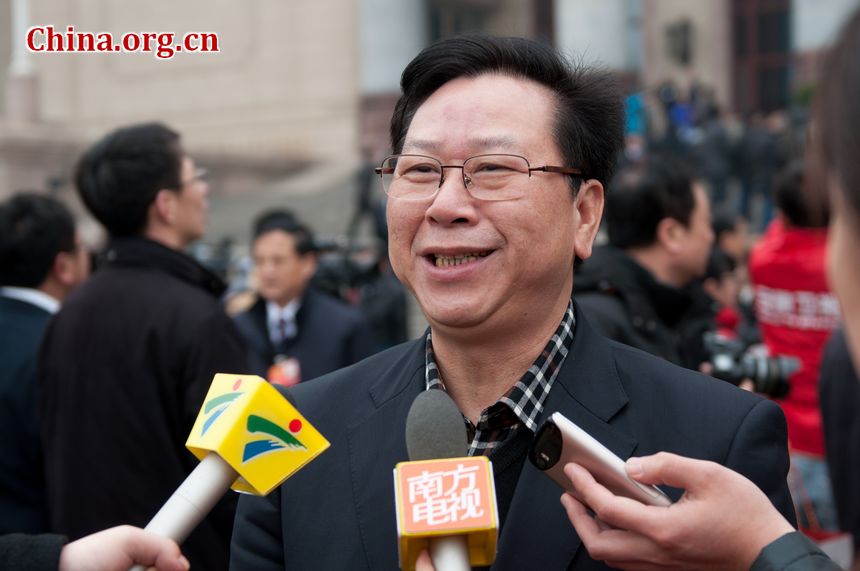 A delegate from Guangdong Province is surrounded by Cantonese media as he walks out of the Great Hall of the People in Beijing, China on Monday, March 5. [China.org.cn]