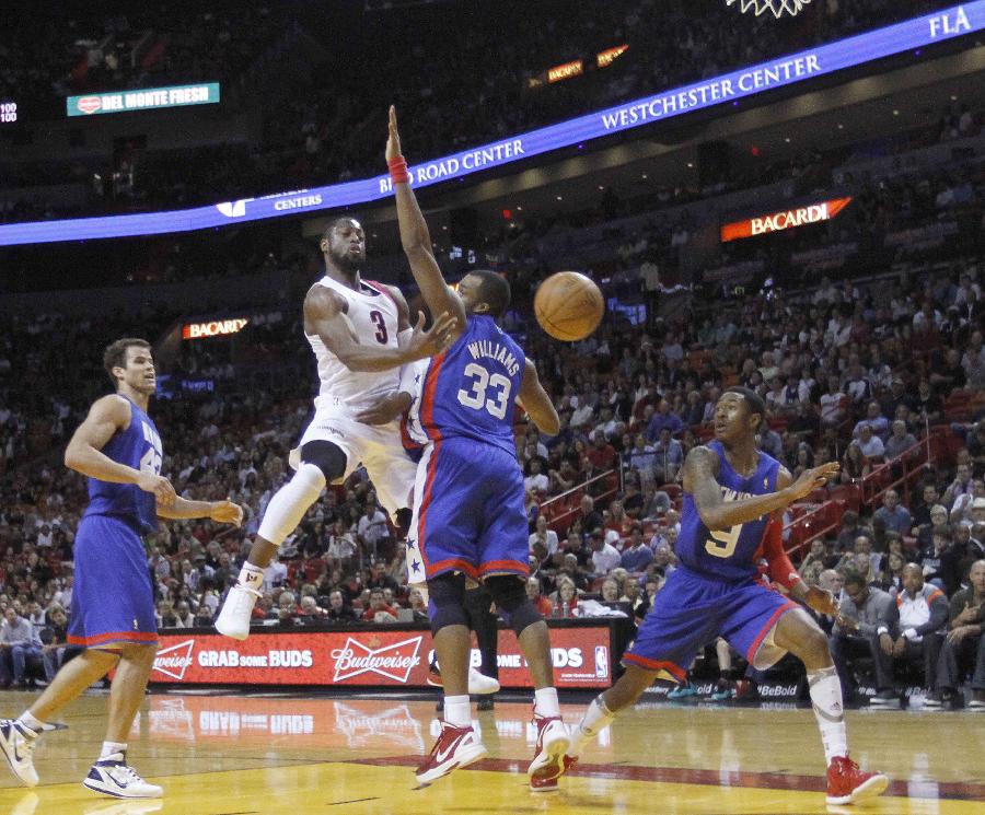 The Miami Heat's Dwyane Wade (2nd L) is defended by the New Jersey Nets' Shelden Williams during their NBA basketball game in Miami, Florida March 6, 2012. Heat won 108-78. (Xinhua/Reuters Photo) 