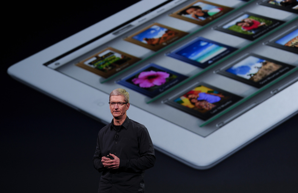 Apple CEO Tim Cook speaks during an Apple event as he introduces the new iPad as an image the device is projected on screen in San Francisco, California March 7, 2012. [Xinhua] 
