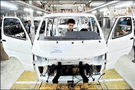 A Chinese carmaker's employees work at a factory in Shenyang, Liaoning Province, yesterday. Passenger car sales in China fell 1.4 percent in the first two months of this year. [Shanghai Daily]