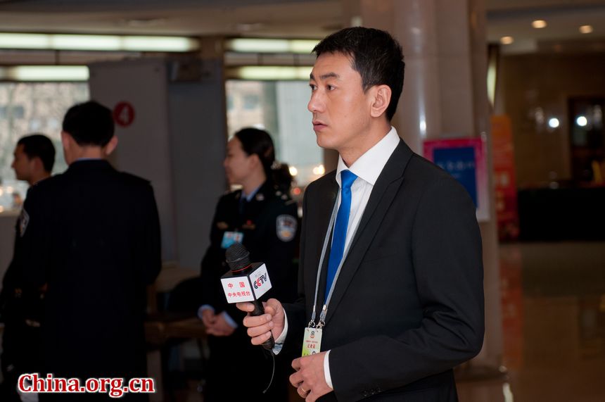 Lu Jian, a well-known TV host with CCTV conducts live broadcast at the NPC Press Center on Thursday afternoon, March 8, 2012. [China.org.cn]