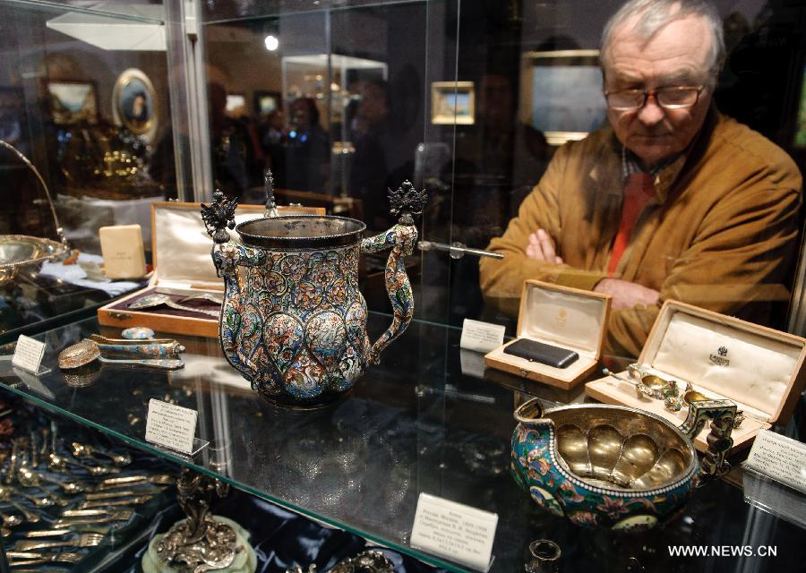 A man views items displayed at the 32 session of Russian International Exhibition of Antiques in Moscow, capital of Russia, March 9, 2012. Some 200 exhibitors attended the exibition which opened on Friday. (Xinhua/Jiang Kehong) 