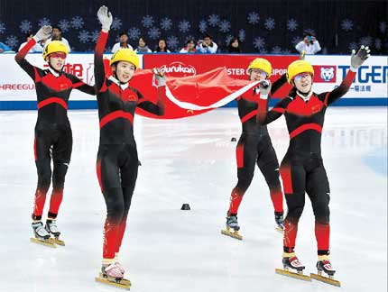 The foursome of Li Jianrou, Fan Kexin, Liu Qiuhong and Kong Xue parade the Chinese national flag after winning the women's 3,000-meter relay at the ISU world short-track speedskating championships in Shanghai yesterday. 