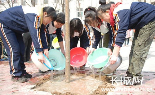 Students plant trees on the 34th national Tree Planting Day in Xingtai, Hebei Province, March 12, 2012. 