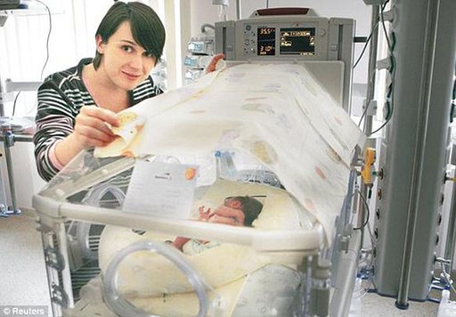 Joanna Krzysztonek with one of her surviving babies after she was able to hold off giving birth for 75 days. [Agencies]