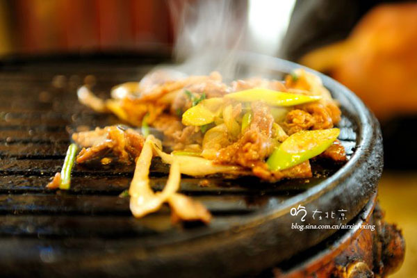 Thin slices of mutton are dipped in sauces before they are grilled. [Photo:sina.com.cn]