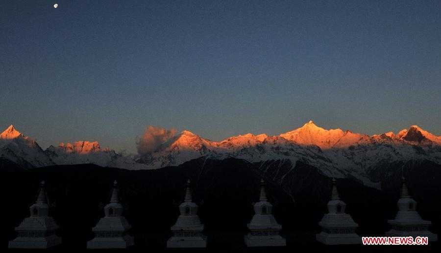 Photo taken on March 12, 2012 shows the Meili Snow Mountain during sunrise in Deqin county, Diqing Tibetan Autonomous Prefecture, in southwest China's Yunnan province. The Meili Snow Mountain, with the highest peak at an altitude of 6,740 meters, is covered with glaciers formed thousands of years ago. Dozens of splendid snow mountains in northwest Yunnan make the province a dreamland of tourism. (Xinhua/Chu Xuejun)