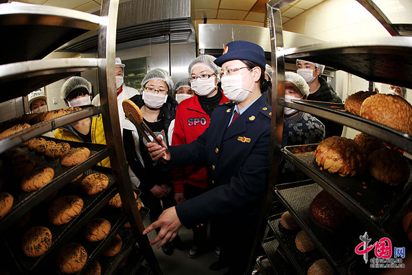 People visit a supermarket in Huaibei, Anhaui Province, where an official gives them an introduction of the production line of foods on March 14, ahead of the Consumer Rights Day on March 15. [China.org.cn] 